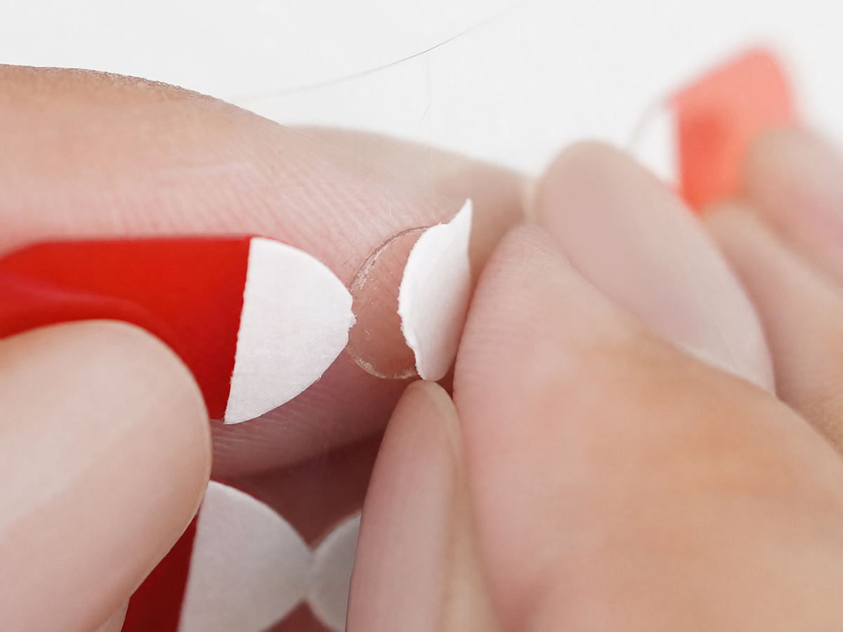 Peel away the cat-shaped top layer while keeping the adhesive base in place